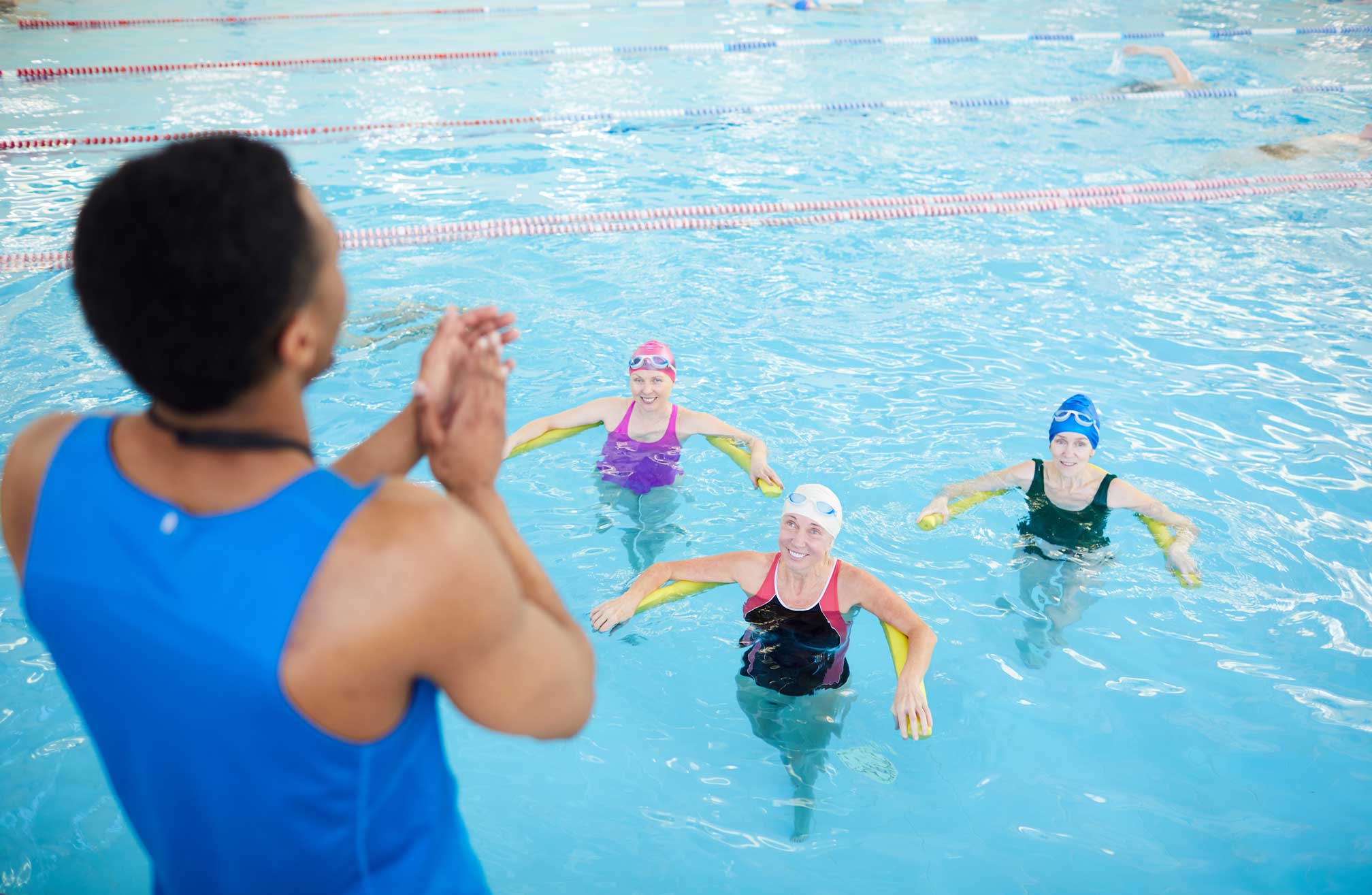 Certified instructor teaching adults in a structured swim class.