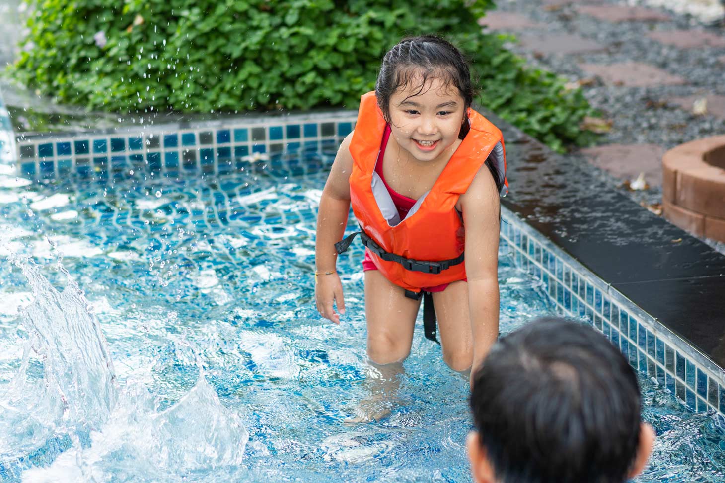 Swim instructor guiding a child through essential water safety training in a pool.